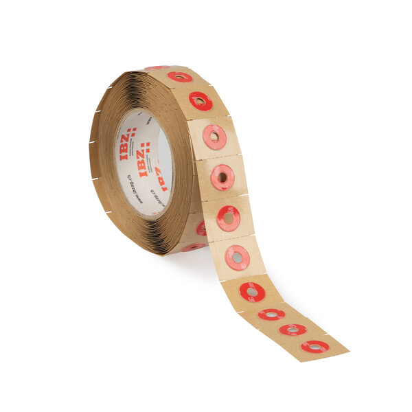 Pièces étampées sur liner brun, dans ruban adhésif acrylique double face avec protecteur rouge en PE. Rondelles avec trou intérieur chassé, avec perforations pièce par pièce dans liner.  