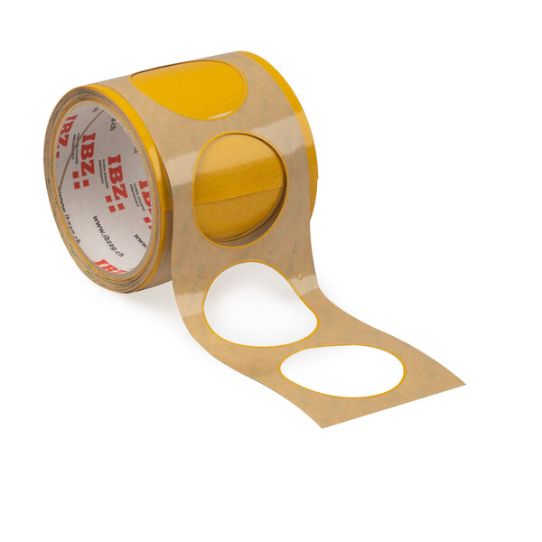 L'illustration montre des pièces étampées autocollantes en forme de rondelles avec une barrette étroite. Le liner est brun, l'arrière-plan est blanc. 
