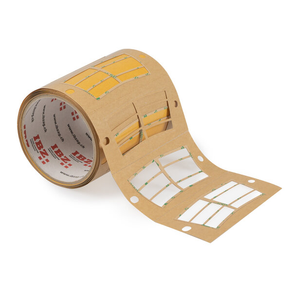 L'illustration montre une fabrication individuelle d'un ruban adhésif, la colle ayant été découpée en 6 petits rectangles. Le ruban est brun, le fond est blanc.