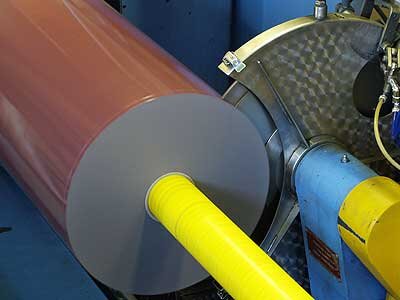 Machine à tronçonner L'illustration montre un rouleau de ruban adhésif découpé à une largeur donnée par une lame à droite. Le ruban est brun et la barre de torsion est jaune fluo.